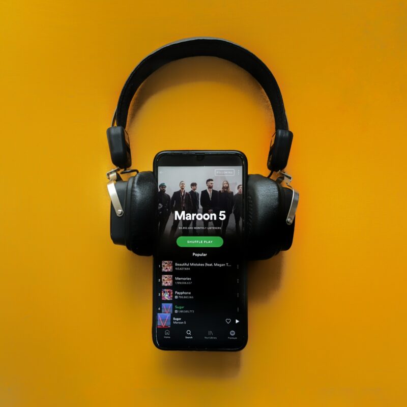 Photograph of headphone on phone with Spotify app